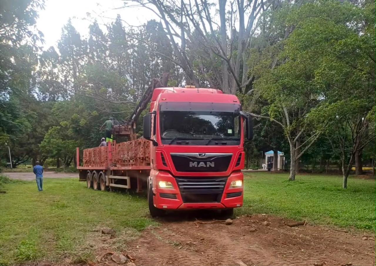 MAN grab truck loading bricks outdoors