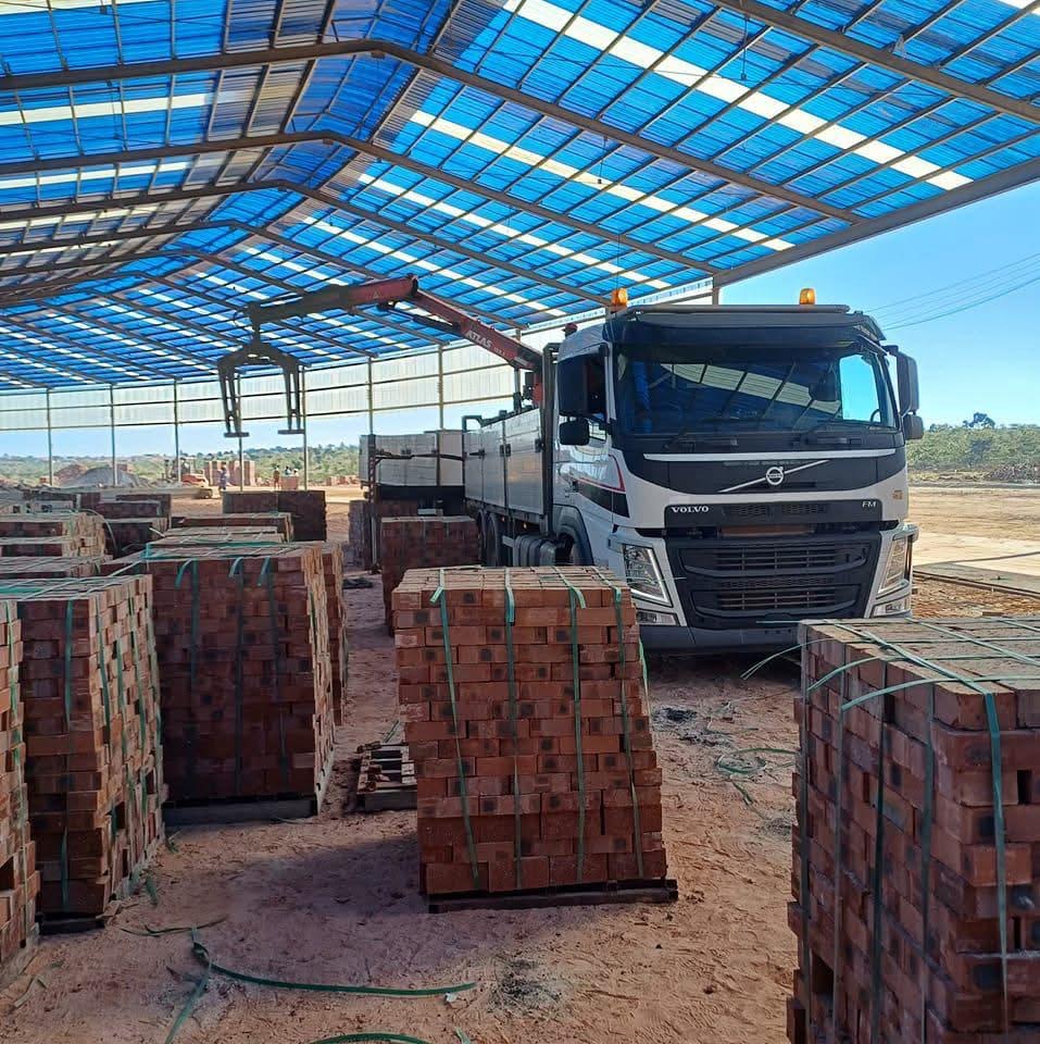 Volvo FM grab truck loading bricks under a brick yard canopy